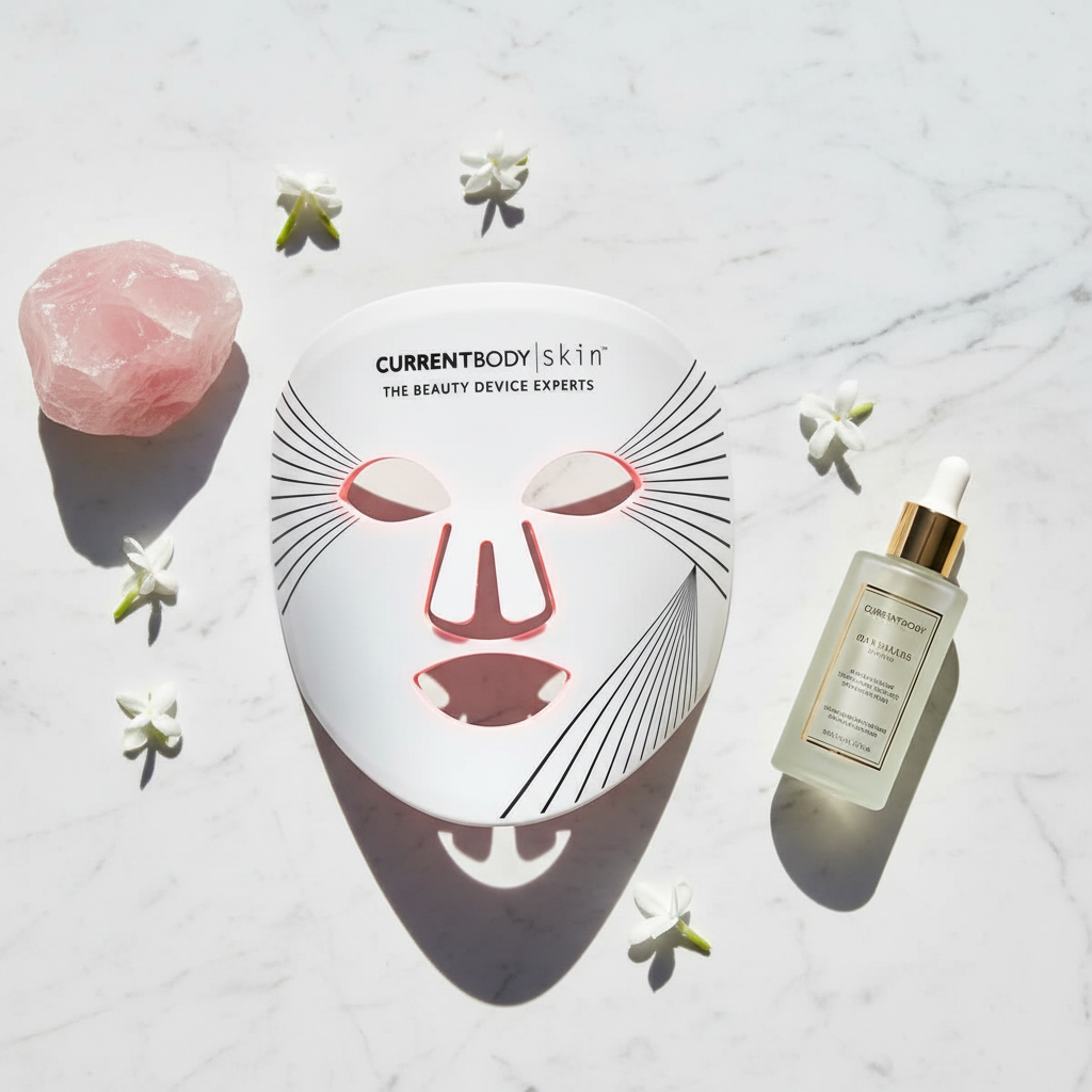 CurrentBody Skin LED Face Mask flatlay on white marble with rose quartz and luxury skincare serum